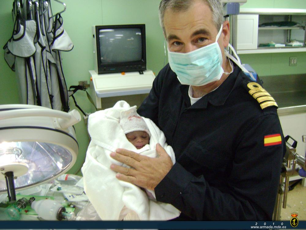 El comandante del BAA Castilla Francisco Peñuelas con el recién nacido en sus brazos.