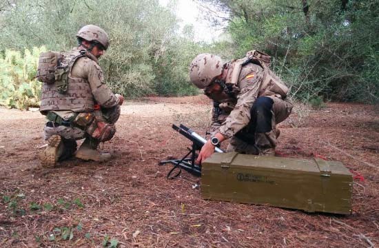 EOD personnel operating a disruptor gun on an ammo box.